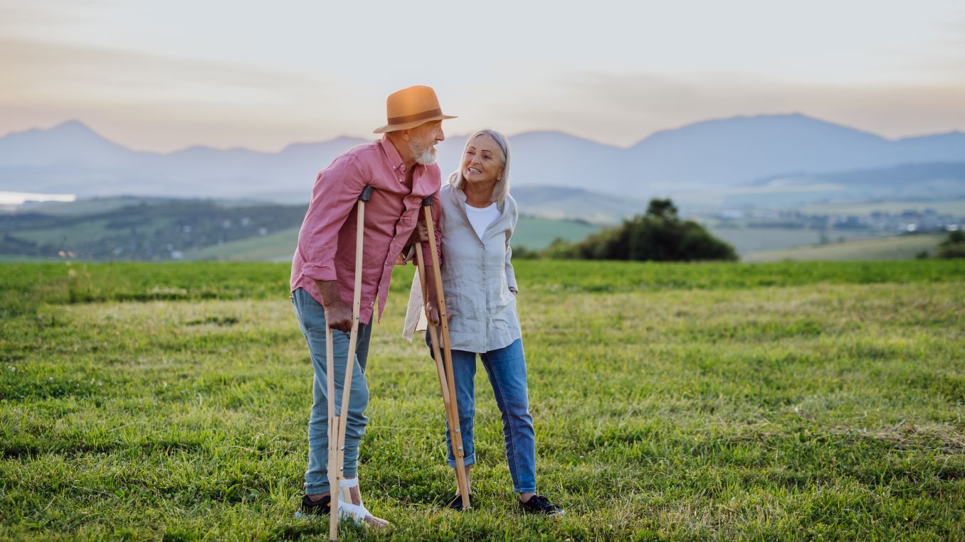 And aging man and woman. The man has crutches. They are in a field at dusk